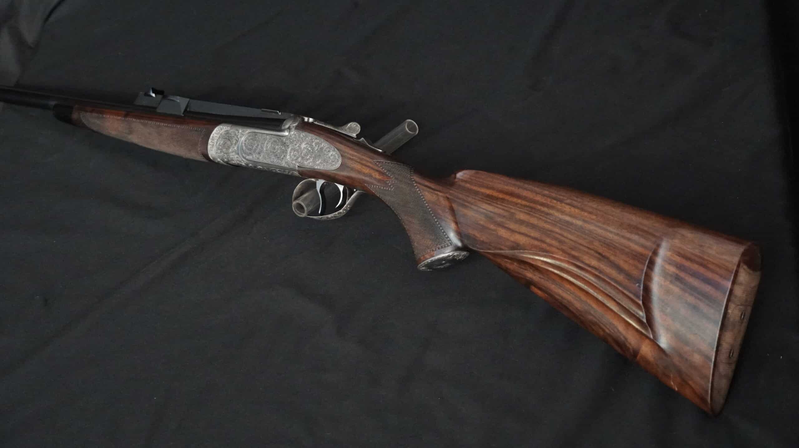 Double express de luxe, crosse en noyer veiné, poignée quadrillée. Boîtier de culasse argenté finement gravé de volutes.