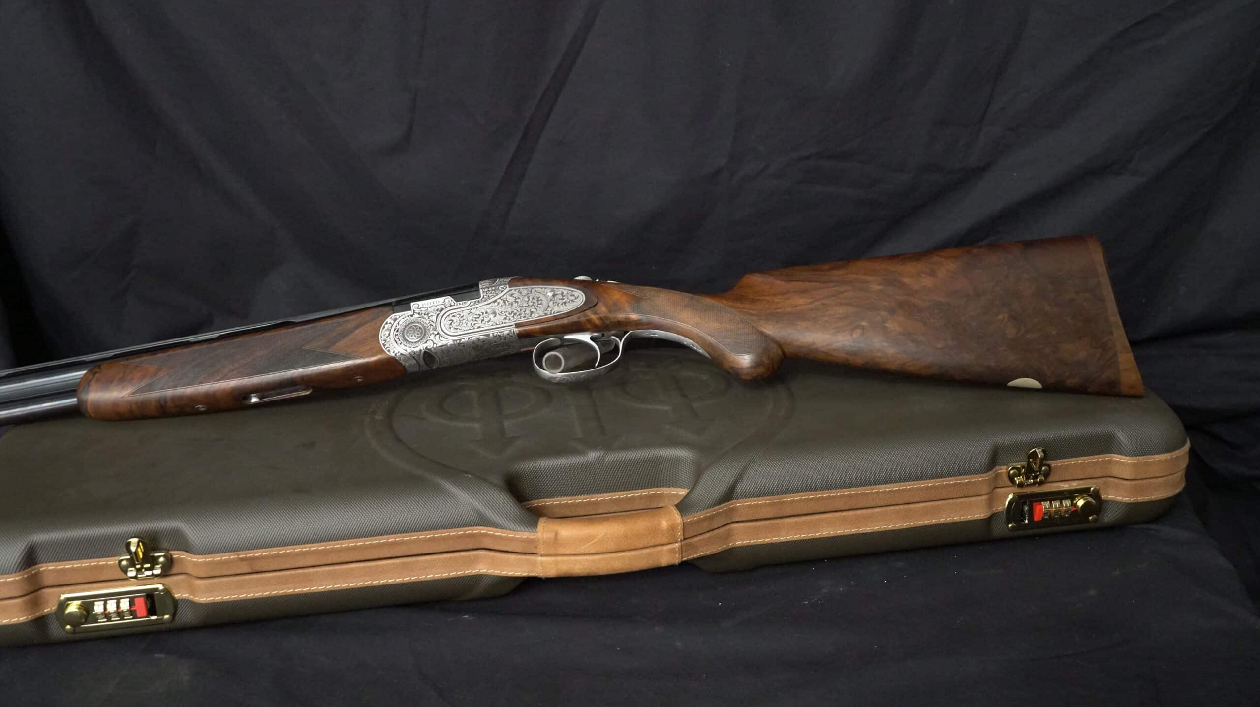 Fusil superposé Beretta avec gravures fines posé sur sa mallette de transport rigide.