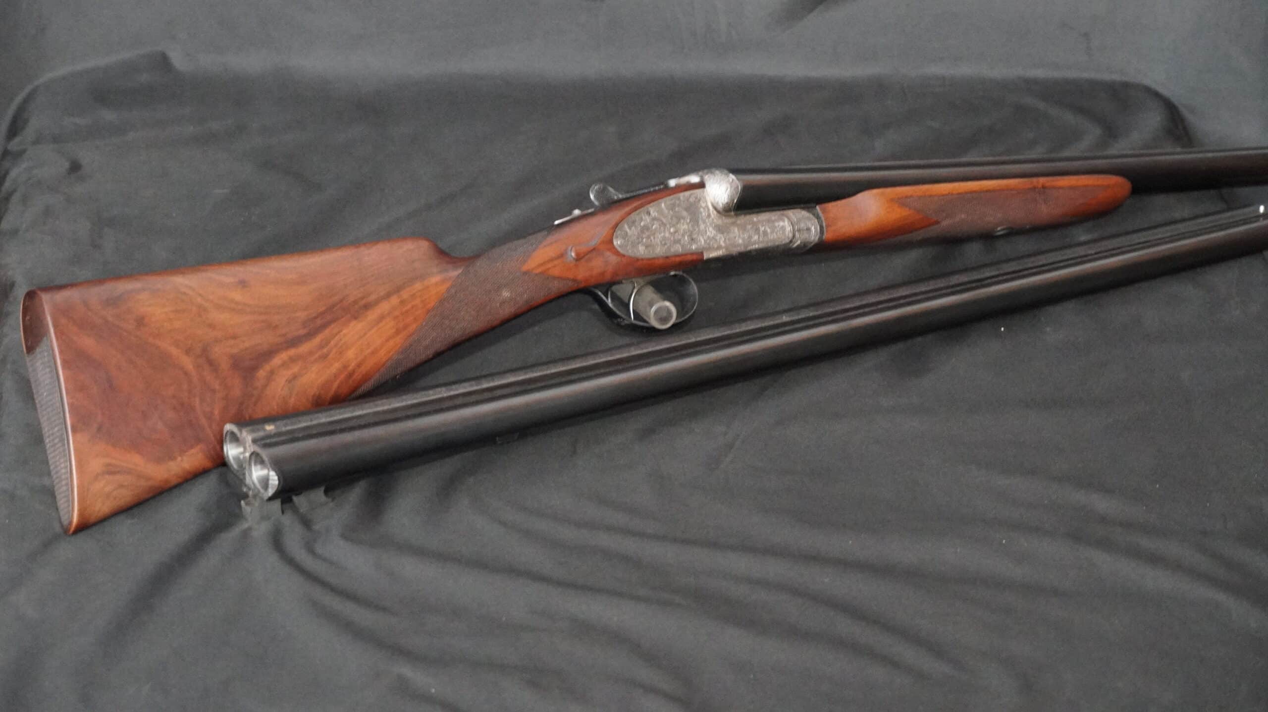 Fusil juxtaposé à doubles canons démonté, avec une crosse en bois de noyer richement veiné et une platine gravée.