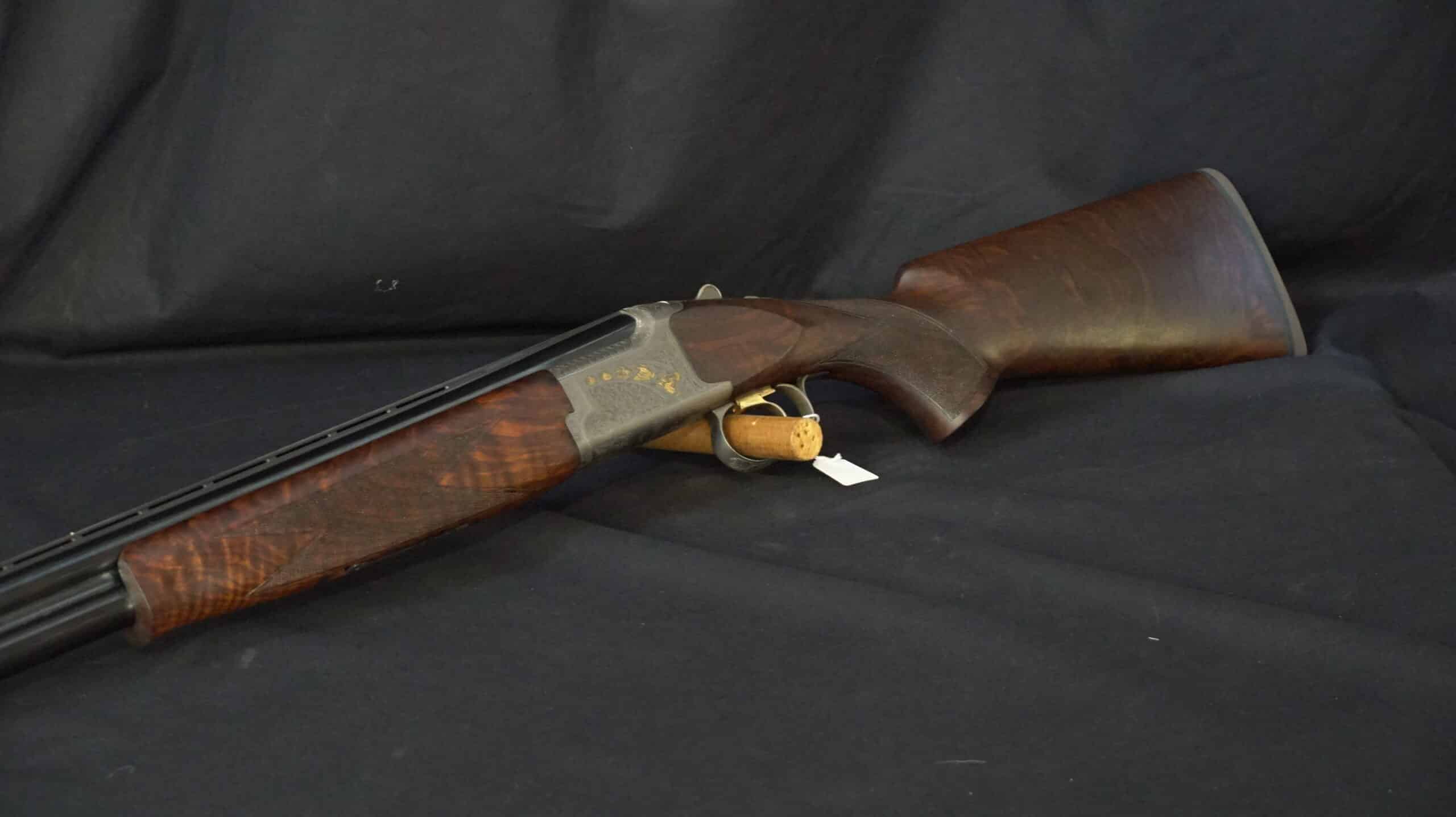 Fusil superposé de luxe. Crosse et devant en noyer flammé, boîtier gravé. Bouchon de sécurité en liège dans le pontet.