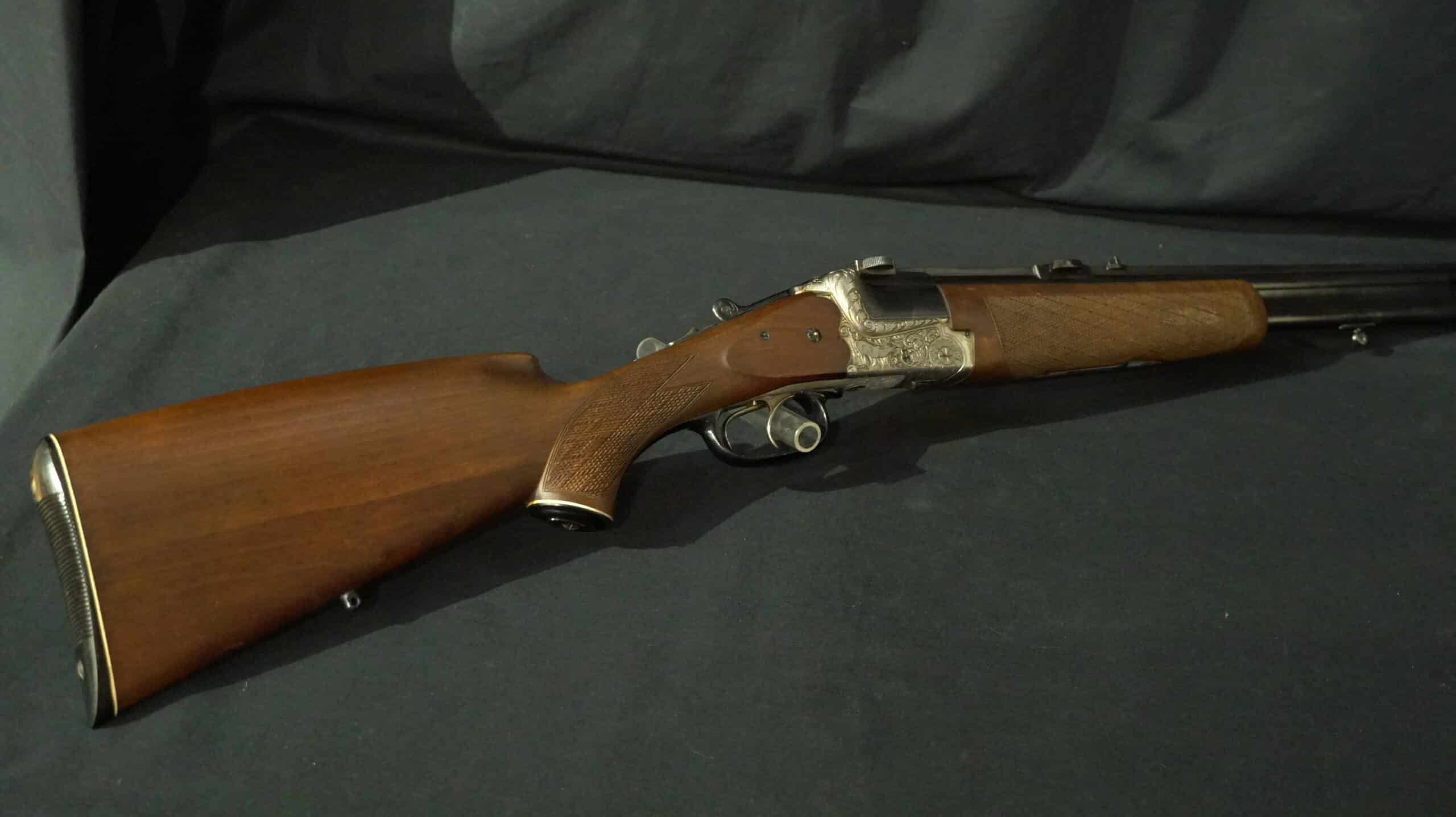 Carabine double de chasse haut de gamme avec crosse en bois de noyer. Détails fins, pontet, et bascule gravée à la main.