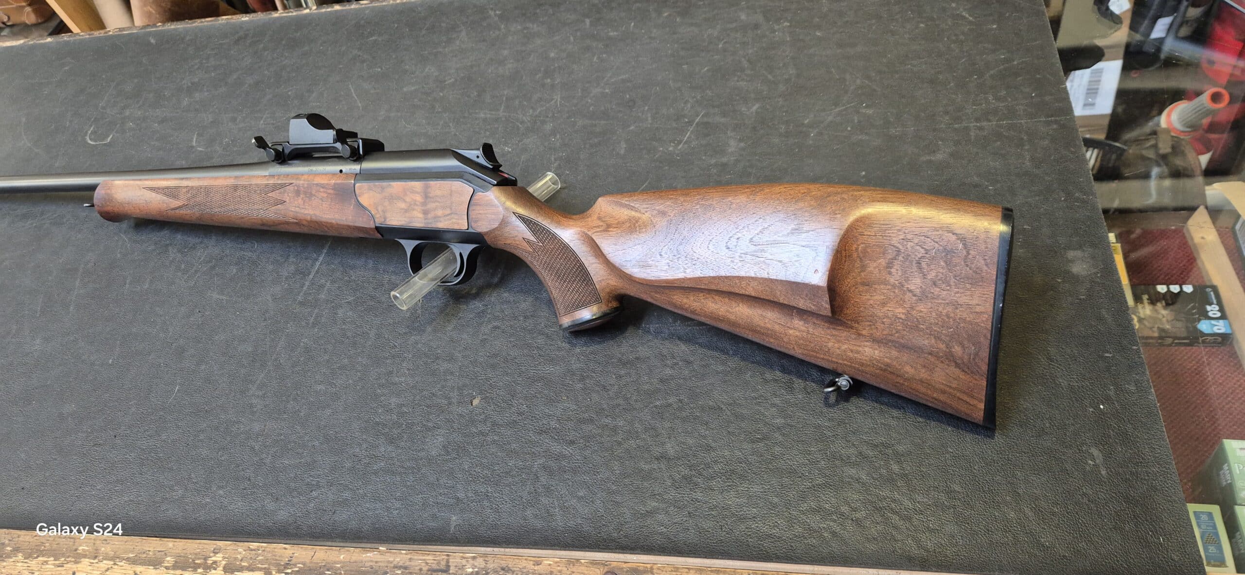 Carabine de chasse calibre .30-06 à verrou linéaire, crosse en bois de noyer et viseur point rouge monté.