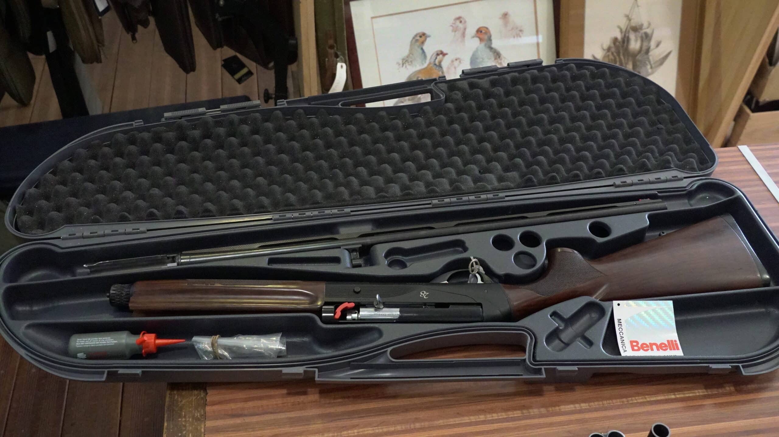 Fusil Benelli 28 semi-automatique démonté dans sa mallette rigide avec accessoires de nettoyage.